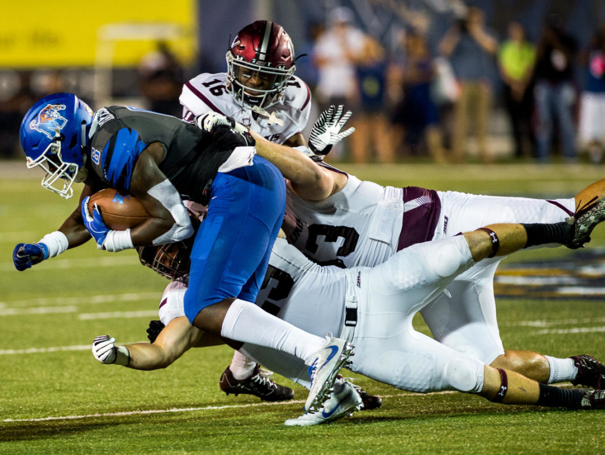 University of Memphis sophomore running back Patrick Taylor Jr. (6) is tackled by SIU senior inside line backer Markese Jackson (13), sophomore inside linebacker Cody Crider (29), and sophomore safety James Caesar (16) Saturday, Sept. 23, 2017, during the Salukis game against the University of Memphis at the Liberty Bowl Memorial Stadium in Memphis, Tennessee. (Dylan Nelson | @DylanNelson99) 