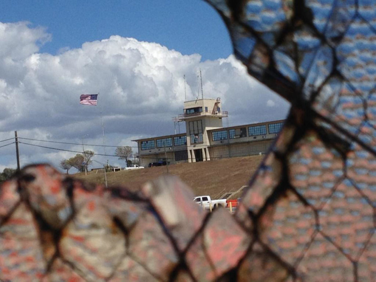 The war court headquarters at Camp Justice, as seen through a broken window at an obsolete air hangar at the U.S. Navy base at Guantanamo Bay, Cuba, on Feb. 28, 2015, in an image approved for release by the U.S. military. Defense lawyers are asking a federal judge to intervene in a ccaptives Guantanamo medical care. (Carol Rosenberg/Miami Herald/TNS)