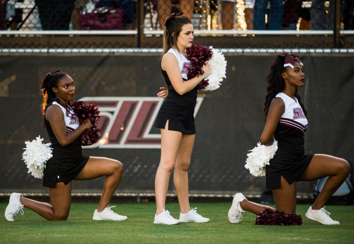 Sophomore radio, television and digital media major Czarina Tinker, of Nashville, Tennessee, left, and sophomore psychology major Ariahn Hunt, of Chicago, far right, kneel during the national anthem Saturday, Sept. 30, 2017 before the Salukis matchup against the University of Northern Iowa Panthers at Saluki Stadium. President Donald Trump publically criticized NFL athletes who kneel during the National Anthem to protest police brutality, late last month.
(Brian Muñoz | @BrianMMunoz)