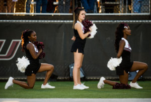 Sophomore radio, television and digital media major Czarina Tinker, of Nashville, Tennessee, left, and sophomore psychology major Ariahn Hunt, of Chicago, far right, kneel during the national anthem Saturday, Sept. 30, 2017, before the Salukis matchup against the University of Northern Iowa Panthers at Saluki Stadium. President Donald Trump publicly criticized NFL athletes who kneel during the National Anthem to protest police brutality last week. (Brian Muñoz | @BrianMMunoz)