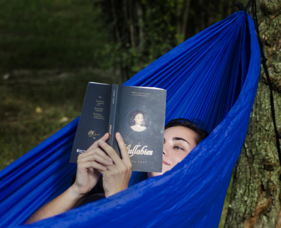 Tayler Goldtrap, a junior forestry major from Kankakee, reads a poetry book while relaxing in a hammock on Aug. 22, 2017, at Thompson Point, in Carbondale. “I chose this spot because it was near my dorm building and the trees were positioned perfectly to connect my [hammock] attachments,“ Goldtrap said. “I was reading the book ‘Lullabies’ by Lang Leav because I was looking for inspiration to write again.” (Dylan Nelson | @DylanNelson99)