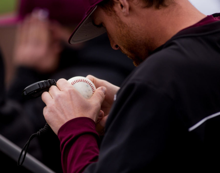 A Saluki baseball staffer inspects a game ball Saturday, March 10, 2018, during the Salukis 7-2 victory against the Northern Illinois University Huskies at Itchy Jones Stadium. (Brian Munoz | @BrianMMunoz)