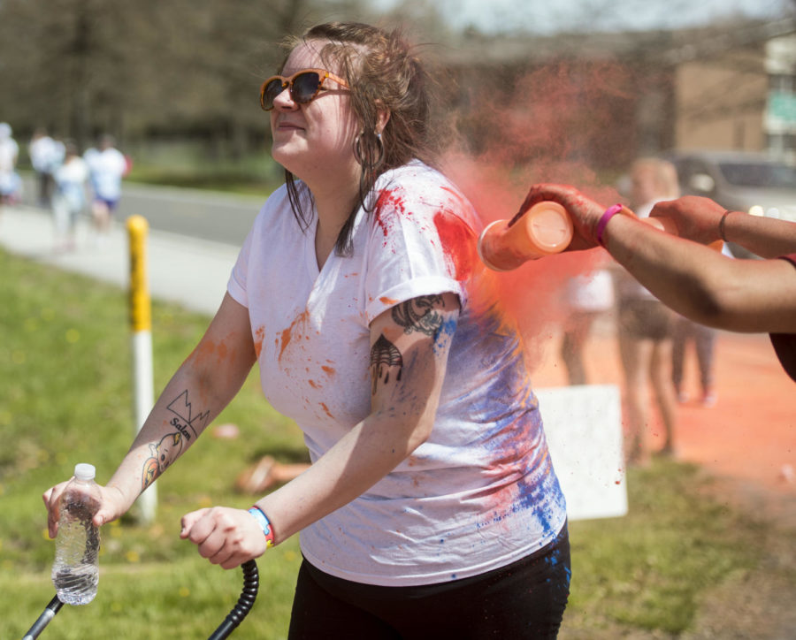 Chelsea Housden of Carbondale is doused in orange powder, Saturday, April 21, 2018, during the Autism Society of Southern Illinois 5k color run around SIUs Lew Hartzog Track Complex. (Mary Newman | @MaryNewmanDE)
