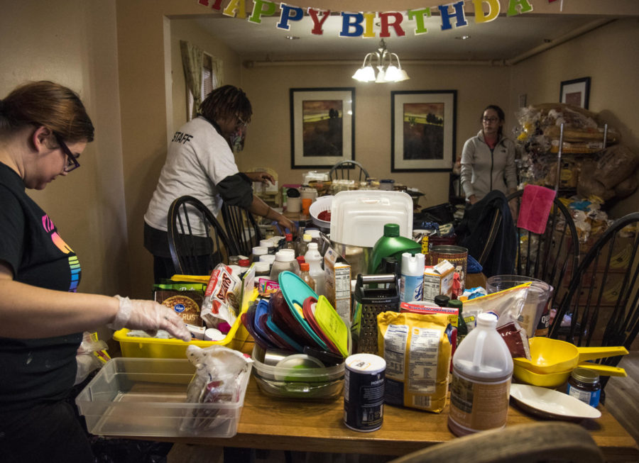 From left: Kristyne Haring, of Geneva, Rebekah Sanders, of Belleville, and Morrighan O’Connell of St. Louis, Mo. sort through food and dishes, Saturday, April 7, 2018, at the Carbondale Women’s Center as volunteers for SIU’s The Big Event. (Mary Newman | @MaryNewmanDE)