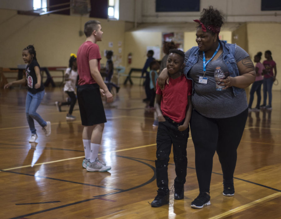 Adonis Spearman, right, 9, of Carbondale, walks with volunteer Brianna Lane across the gym on Friday, April 13, 2018, at the Boys & Girls Club of Carbondale. (Mary Newman | @MaryNewmanDE)
