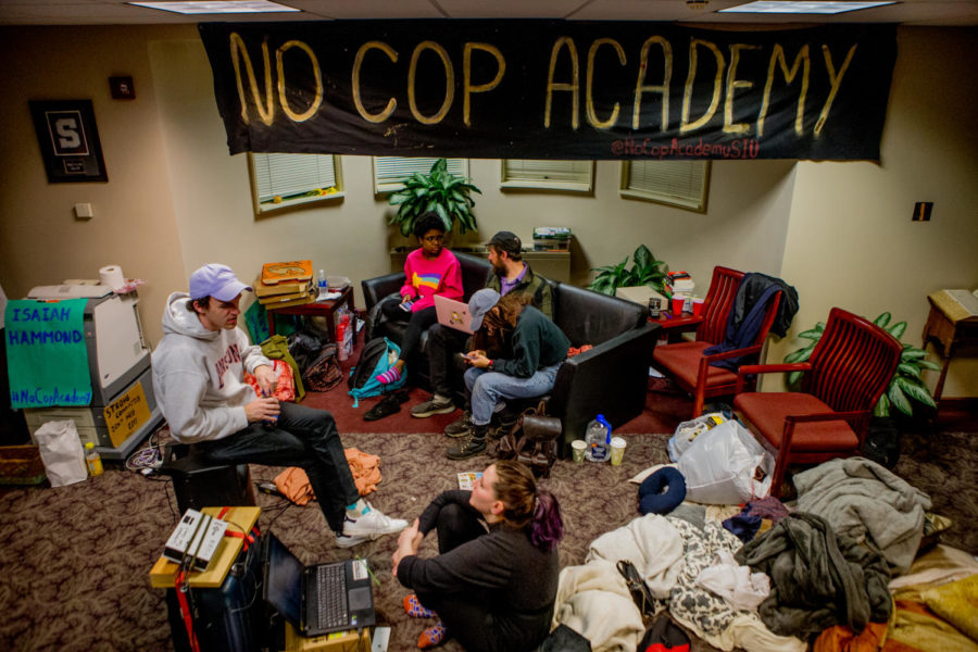 Demonstrators talk with each other on community Friday, April 6, 2018, during an occupation of SIU Chancellor Carlo Montemagnos office in Anthony Hall. The occupation followed a march through campus the previous day in protest of the proposed police academy at the Southern Illinois University Carbondale campus. (Brian Munoz | @BrianMMunoz)