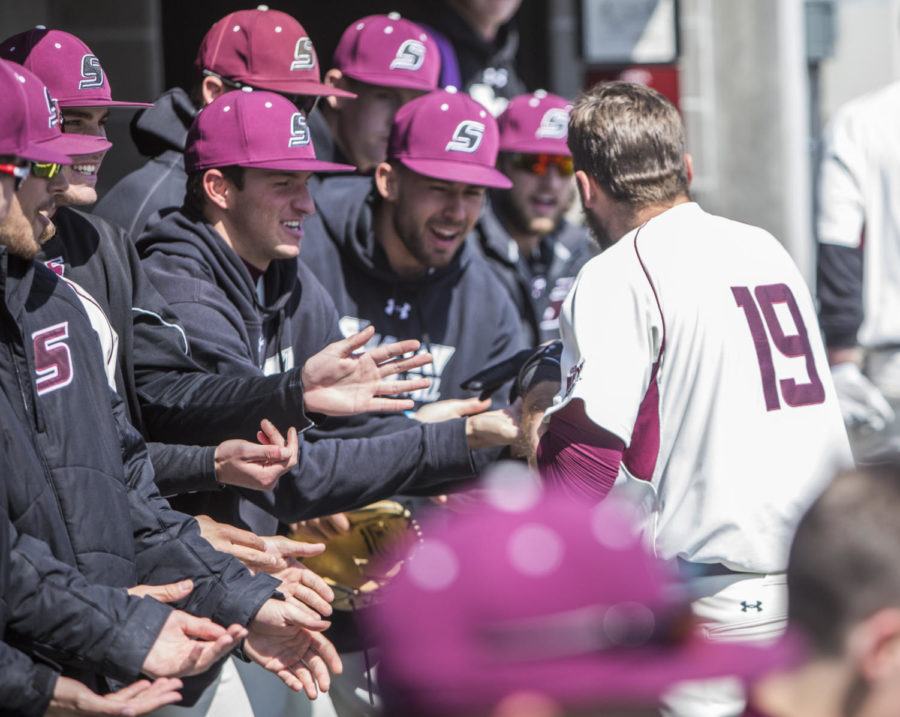 Southern Illinois senior infielder Drew Curtis (19) gets congratulated by his teamates after hitting a homerun, Saturday, April 7, 2018, during the Valparaiso University Crusaders 6-2 victory against the Southern Illinois Salukis at Itchy Jones Stadium. (Corrin Hunt | @CorrinIHunt)