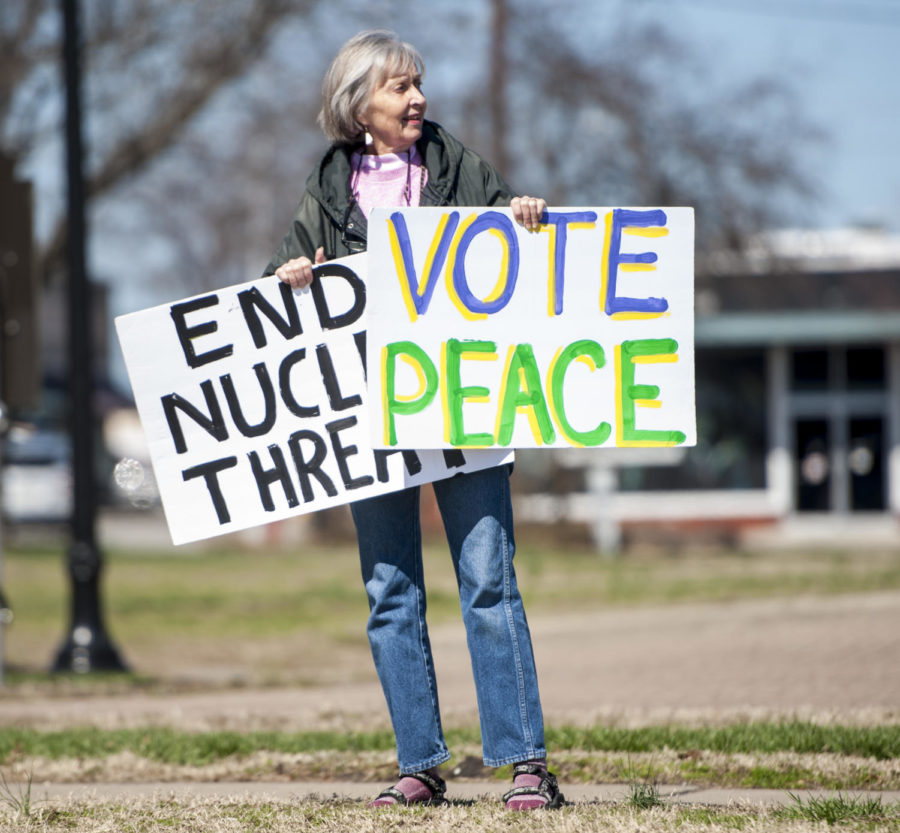Judy Ashby of Carbondale holds signs during a vigil held by the Peace Coalition of Southern Illinois, Saturday, March 3, 2018, on the corner of North Illinois Avenue and East Main Street. ÒWar has never made sense. Collaborating and helping one another is the only thing that will allow this species to survive,Ó said Ashby. (Mary Newman | @MaryNewmanDE)