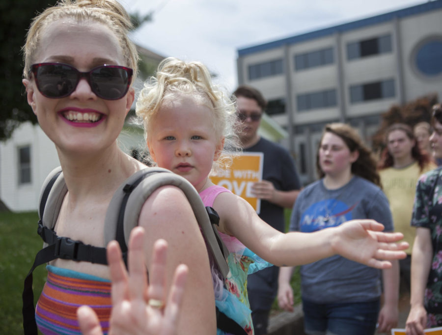 Zhenya Hogsett and daughter Margaret wave to honking cars during the Pride Walk, the pair are participating with the VA, Saturday, June 2, 2018, Carbondale. (Isabel Miller)