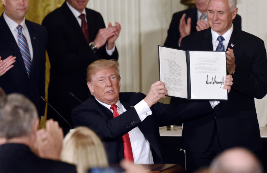 President Donald Trump holds a signed National Space Directive to establish a Space Traffic Management program to address the congestion of satellites and space vehicles in Earths orbit during a meeting with the National Space Council on Monday, June 18, 2018 in the East Room of the White House, in Washington, D.C. (Olivier Douliery/Abaca Press/TNS)