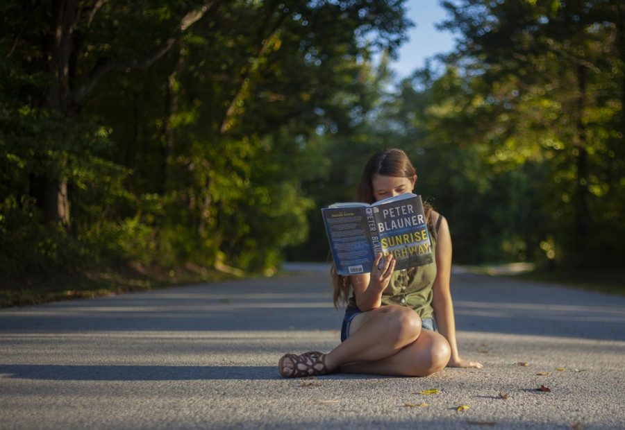 Staff writer, Rana Schenke, reads the thriller “Sunrise Highway” by Peter Blauner, on the SIU campus, Wednesday, Sept. 25, 2018. (Isabel Miller | @IsabelMillerDE)