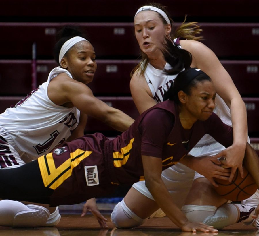 Southern Illinois Saluki guard Kristen Nelson and Forward Abby Brockmeyer grapple for the ball on Sunday, Jan. 27, 2019, during the Southern Illinois Salukis 74-63 win over the Loyola Ramblers at SIU Arena. 