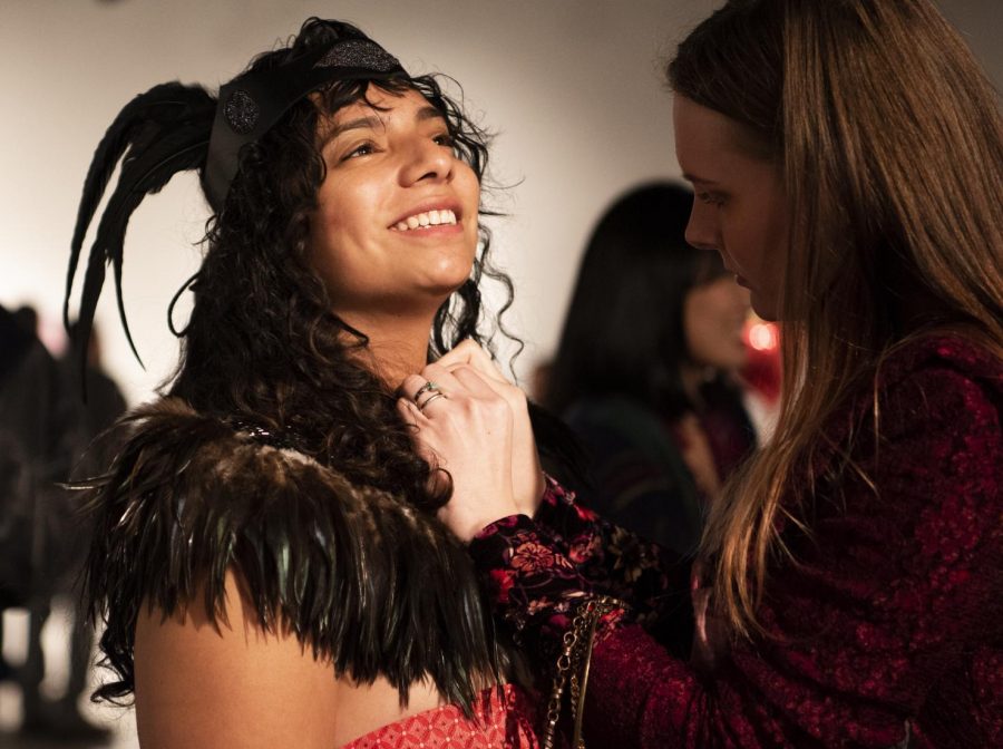 Sophia Julio, a senior majoring in anthropology, has her necklace adjusted on Friday Feb. 8, 2019 during the annual Love at the Glove event inside the Glove factory in Carbondale.  