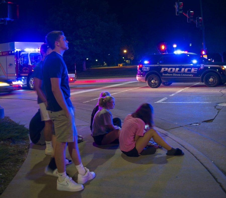 Bystanders watch as first responders direct traffic on Wednesday, Aug. 28, 2019 at the intersection of Grande Ave. and South Illinois Ave. after a two-vehicle collision. 