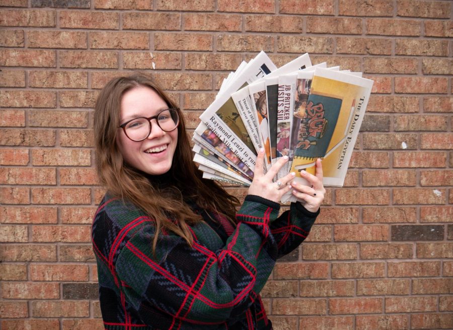 Editor-in-chief Emily Cooper holds up copies of the Daily Egyptian on Dec. 10, 2019.