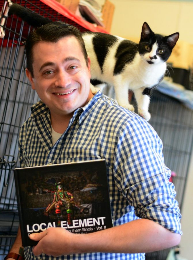 Mark Nycz, a SIU photography graduate student poses for a portrait with his photography book Local Element. Mark donated the profits from his book to the local St. Francis CARE Animal Hospital on Saturday, Feb. 29, 2020  in Murphysboro, IL. 