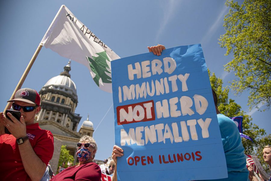A protestor displays a sign during the statewide Reopen Illinois protest on Friday, May 1, 2020 in Springfield, IL. 