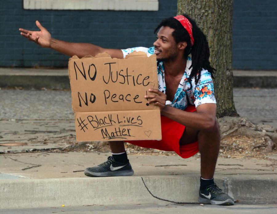Zyon, 24, captures the attention of passing cars during a Black Lives Matter protest at the corner of South Illinois Avenue and West College Street, Wednesday, June 3, 2020, in Carbondale, ILL.