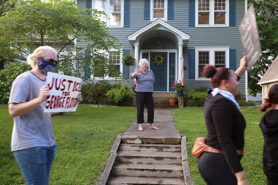 Linda LaFoon waves at Black Lives Matter demonstrators as they march past her home in Anna, IL, Thursday, June 4, 2020.
