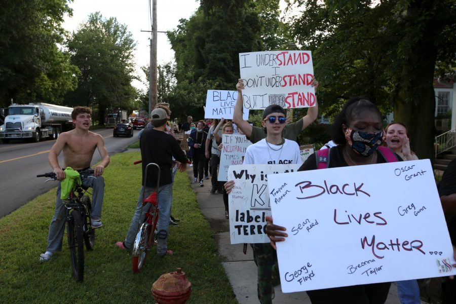 Local kids watch as a group of Black Lives Matter demonstrators march past along a tree-lined street in the town of Anna, Illinois, Thursday, June 4, 2020.
