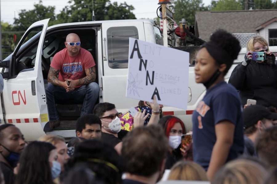 A local resident sits in his work truck while he watches a group of Black Lives Matter demonstrators take a knee during a rally in the town of Anna, Illinois, Thursday, June 4, 2020.
