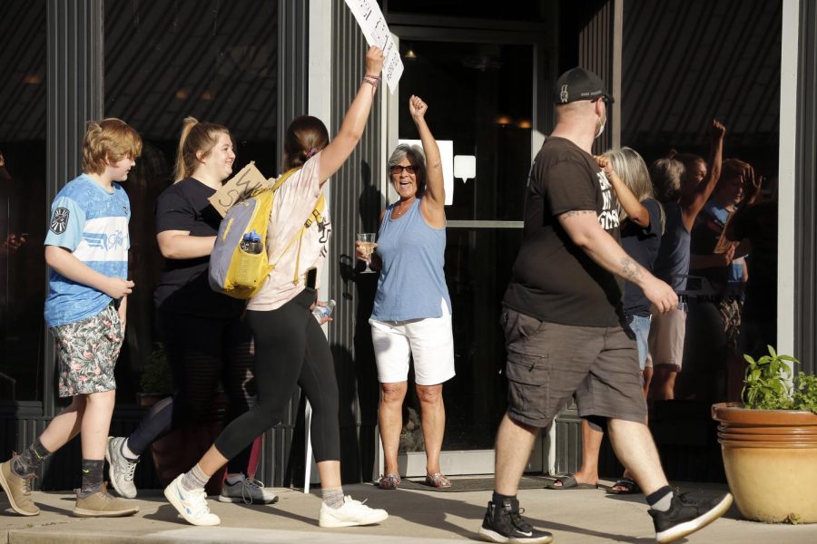 Local residents having a meal at the Brick House Grill step outside to show their support for Black Lives Matter demonstrators as they march along Main Street in the town of Anna, Illinois, Thursday, June 4, 2020.
