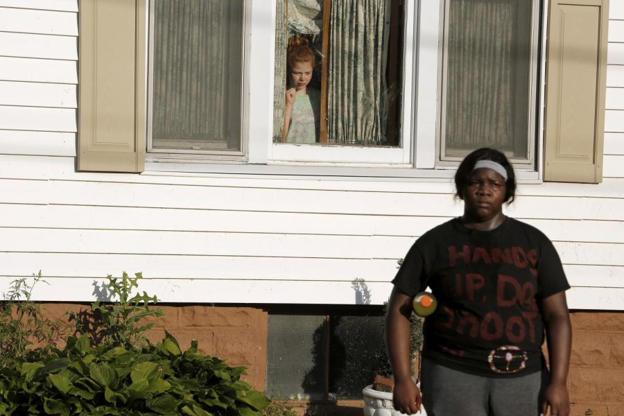 A young white girl looks out of a window as Black Lives Matter demonstrators walk past the home, Anna, Illinois, Thursday, June 4, 2020.
