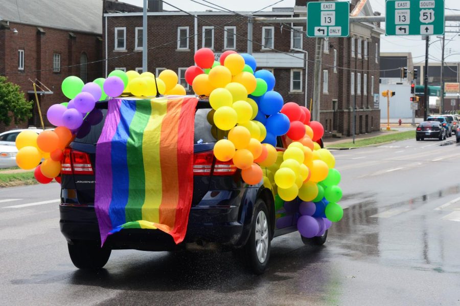 Participants of the 2020 drive-thru Pride parade drive down Monroe Street, June 28, 2020, Carbondale, ILL.