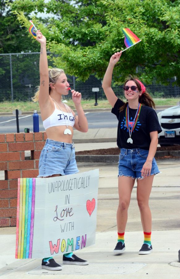 Sydney Browning and Paige Hamel, dance while waving their flags during Pride, June 28, 2020, in Carbondale, Ill.
