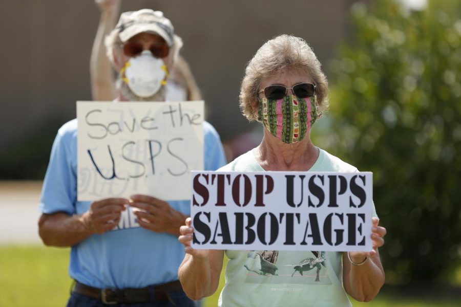 Jean Todd, 72, right, and her husband Jim, 74, behind her, join a group of about 18 other protesters outside the main post office in Carbondale, IL, in solidarity with a nationwide call for a #SaveThePostOfficeSaturday rally on Saturday, August 22 ,2020.
MoveOn, the NAACP, WorkingFamiliesParty, Indivisible and other national organizations announced the nationwide effort to show up at post offices across the country at 11Am on Saturday, August 22, to save the post office from Trump and declare that Postmaster General Louis DeJoy must resign.

Angel Chevrestt // @sobrofotos