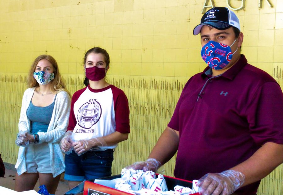 Outside the Agriculture building, students Garrett Williams, Loren Koenigstein, and Caitlyn Tippy pass out sandwiches during the Mask and Meet event on campus from 9:00 a.m. to 3:00 p.m. Monday, August 17, 2020.