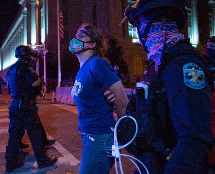 A Louisville Police Officer arrests a female protester Saturday, September 26, 2020 after the 9 pm curfew.
