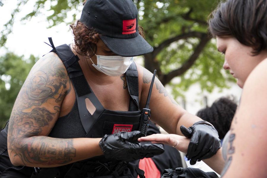 Kara Rexx, a volunteer medic, checks the finger of protester at Jefferson Square Park in Louisville, Ky. on Sept. 25. The kinds of injuries depends. Theres a lot of injuries from riot munitions, heat exhaustion, and the occasional sprained ankle, Rexx said. 
