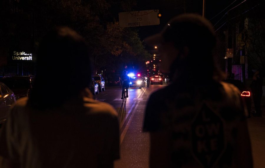 Protesters watch as police back down South 4th St. outside the First Unitarian Church in Louisville, Ky. on Sept. 25. 