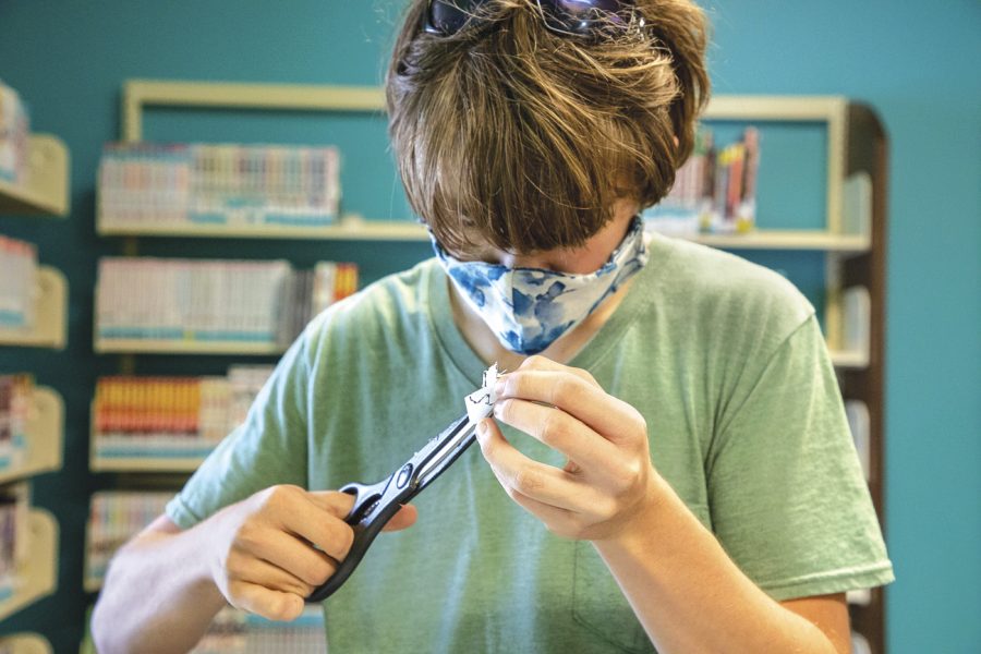 During Teen Craft Night at the Marion Carnegie Library, Anthony Mondzelewski, 16, uses scissors to cut a photo of Glaceon from Pokémon before turning it into shrink art on Aug. 26, 2020.