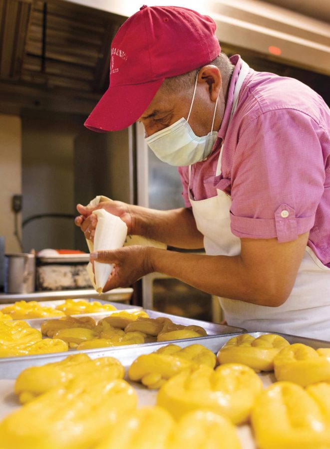 Domingo Valdez, 35, adds butter to pastries before going in the oven at La Unica Bakery, August 27, 2020. 