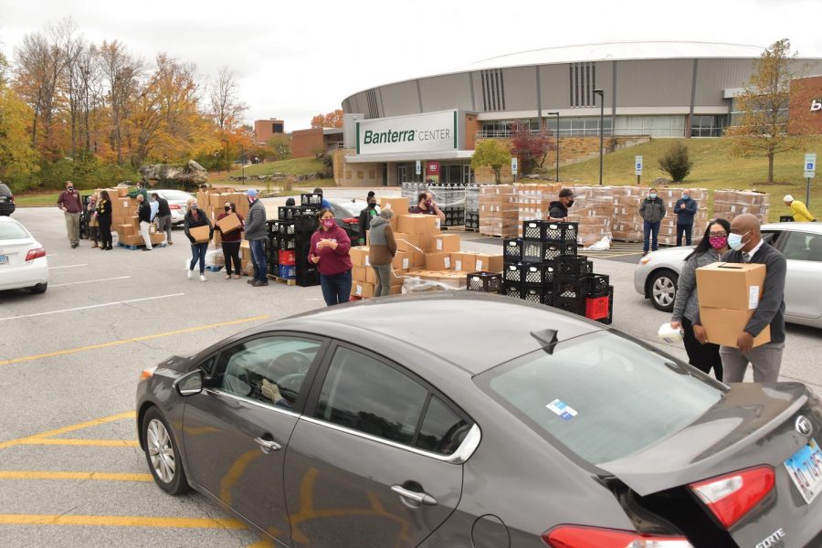 People wait in line at the Pandemic Food Distribution event Monday, Oct. 26, 2020, at the SIU Banterra Center, in Carbondale, Ill. Volunteers help load boxes of food into the cars in line. The food comes from the USDA Farm Table program to help those affected by the pandemic.