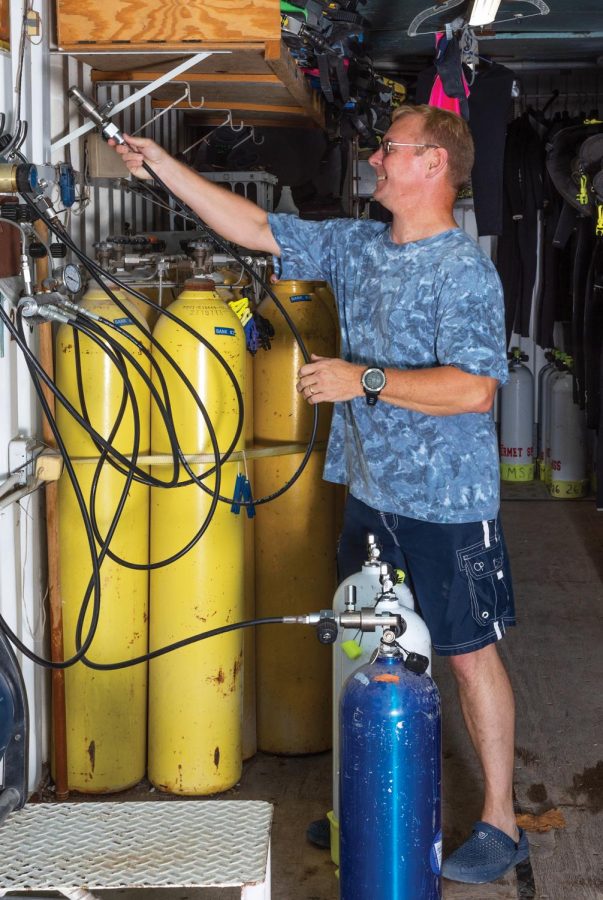 David Shepard, who is in the process of becoming a staff member, finishes filling air tanks Thursday, Oct. 22, 2020. To be on staff at Mermet Springs, people have to volunteer for one or two years to ensure that they are dedicated and want to be on staff.