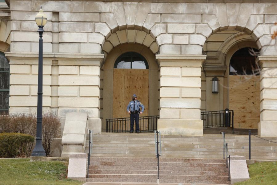 A State Capitol police officer stands watch in front of boarded up windows at the Illinois State Capitol building on Saturday in Springfield.  The FBI released a memo recently to law enforcement agencies across the country warning about potential violent protests at all 50 state capitols after the deadly mob attack on the U.S. Capitol last week.
