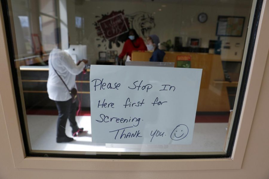 As part of the safety measures in place during the Covid-19 pandemic, a sign on the door to the main office of the Carbondale Middle School instructs visitors to stop in for a body temperature screening before being allowed to enter the school, Carbondale, IL, Friday, November 13, 2020.

Angel Chevrestt // @sobrofotos