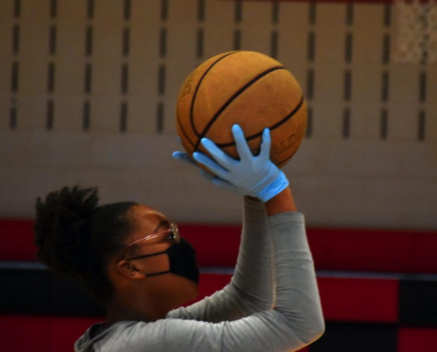  Neviah L., a student at Carbondale Middle School, shoots a basketball Nov. 13, 2020. Students were required to wear rubber gloves during P.E. to help prevent the spread of COVID-19.