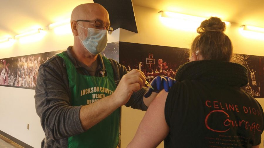 Jackson County Health Department worker, Frank Saunders, administers the Pfizer-Moderna COVID-19 vaccination to Abigail Moberly, a Carbondale local, Thursday, Feb. 11, 2021, in Carbondale, Ill. “They said it’s not bad. They said it doesn’t even feel like you get a shot, ya know? That your arm is sore and that’s about it,” Moberly said.