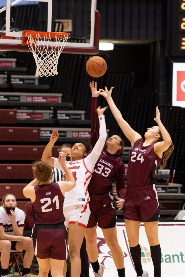 Adrianna Catcher and Rachel Pudlowski leap up to rebound the ball after an unsuccessful attempt by the opponent during the game against Illinois State on Saturday, Feb. 6, 2021, in the Banterra Center at SIU. 