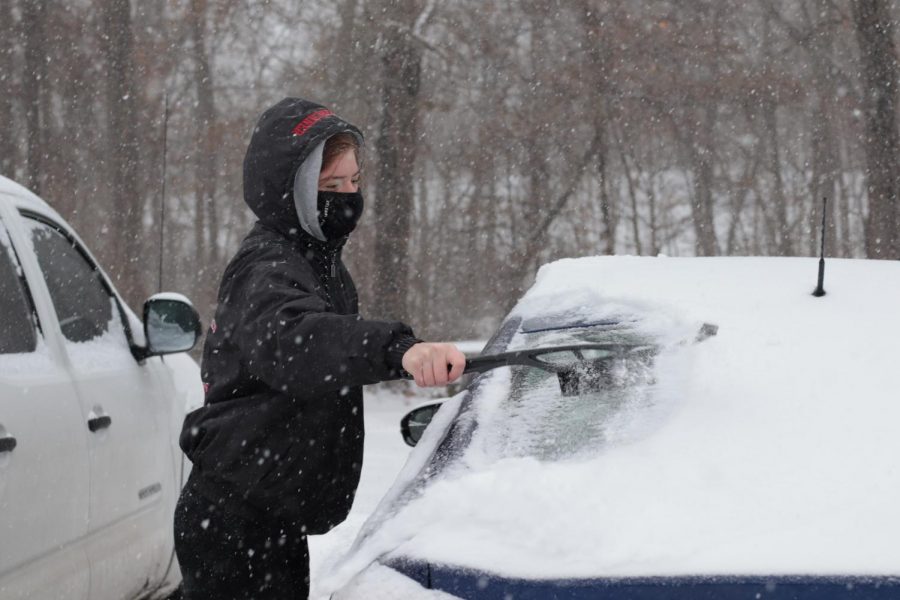 Cassandra Jett clears snow and ice off of her car Monday, Feb. 15, 2021, in Carbondale, Ill.