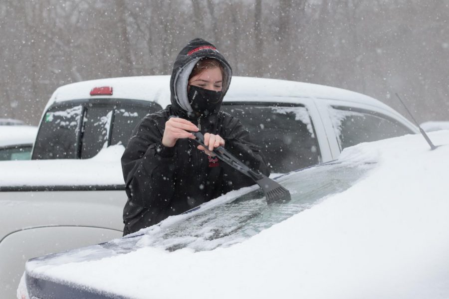Cassandra Jett clears snow and ice off of her car Monday, Feb. 15, 2021, in Carbondale, Ill.