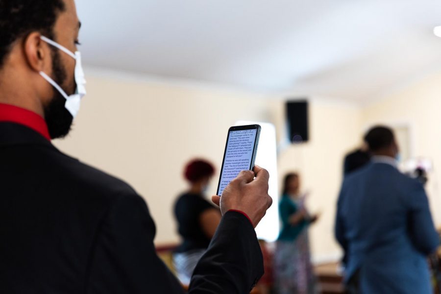 A member of Zion Temple COGIC church follows along with the sermon with his bible on his phone Sunday, Feb. 8, 2021, in Murphysboro, Ill. 
