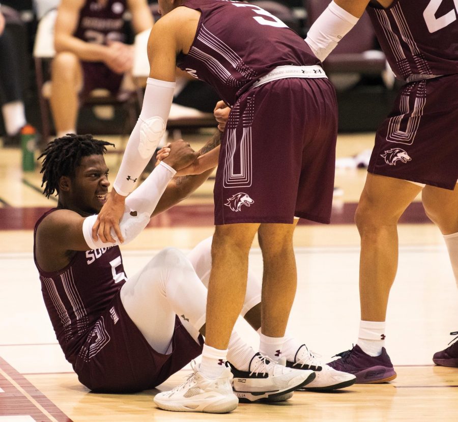 Lance Jones (5) gets help from his teammates to stand after getting fouled during the game against Valparaiso Crusaders on Monday, Feb. 22, 2021, at the SIU Banterra Center in Carbondale, Ill. SIU won the game by 3 points, scoring 67-64.