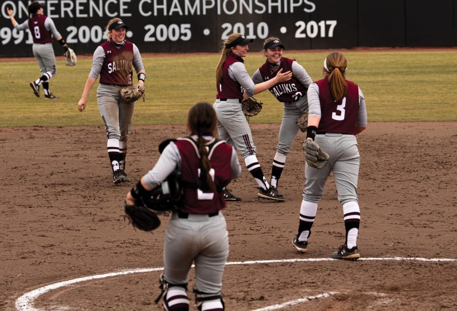 Maddy Vermejen (27) and Ryle Hamilton (1) celebrate after making four runs against Ball State University on Saturday, Feb. 27, 2021 at Charlotte Softball Stadium in Carbondale, Ill. 