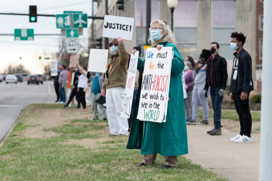 Georgean Hartzog holds signs during the protest on the one-year anniversary of Breonna Taylor’s death on Saturday, Mar. 13, 2021 at the Carbondale Pavilion in Carbondale, Ill. “We always have been an aggressive country taking what we want and not thinking about the consequences and this is very much reflected. I think small changes make a big difference and this step can make a huge impact,” Hartzog said. 