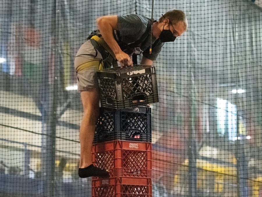 Caleb Meator leans his body to align his center of gravity while attempting to add another crate to his collection during the Crate Stack Challenge held on Tuesday March 16, 2021, at Recreational Center, Carbondale Ill.